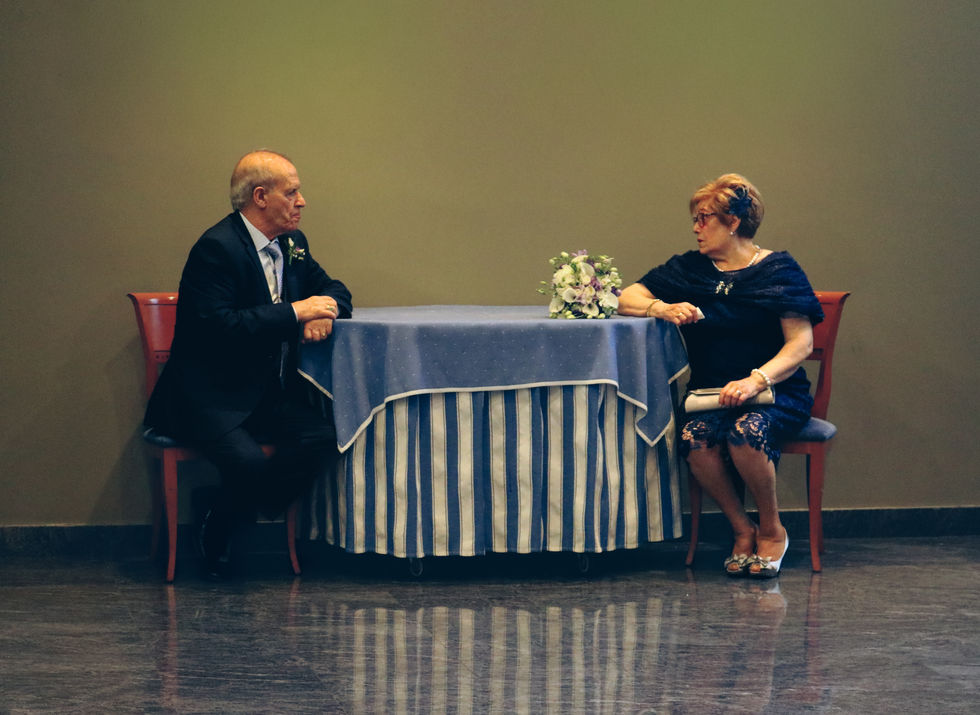 Retrato robado de la pareja que celebra sus bodas de oro, a la espera de poder entrar a la sala de la celebración.