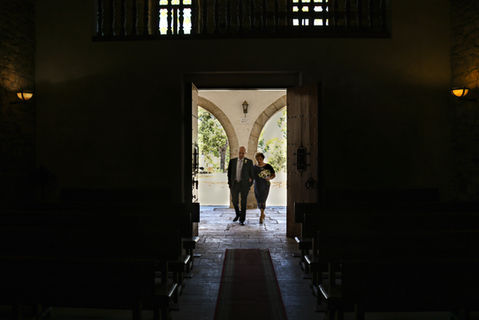 Pareja entrando a la iglesia para celebrar sus bodas de oro. Fotografía tomada desde el centro del pasillo.