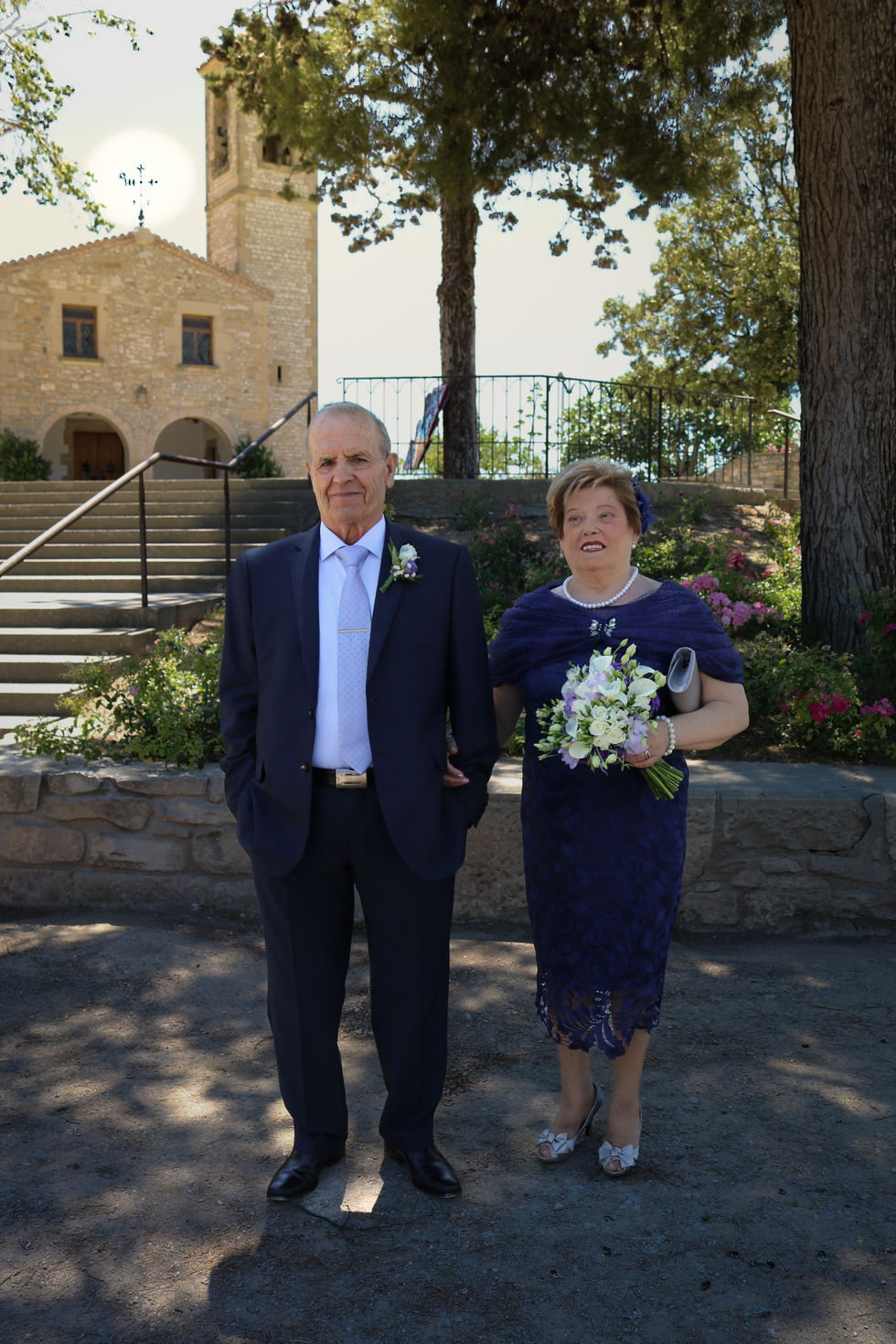Retrato de la pareja donde se aprecia la iglesia de fondo tras salir del oficio de sus bodas de oro.