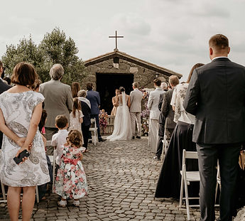 Traurednerin Annika Schilling spricht vor einer kleinen italienischen Kapelle zum Brautpaar und der Hochzeitsgesellschaft.