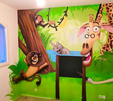 Décoration graffiti d'une salle de jeux sur le thème du dessin animé Madagascar, avec les personnages principaux autours d'un tableaux