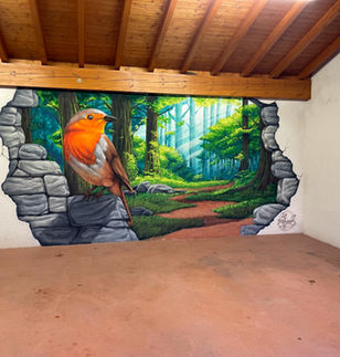 ce trompe-l'œil représente un rouge gorge posé sur un le bord d'un mur cassé au fond d'un garage, dont l'ouverture mène dans une forêt verdoyante.