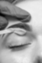 The beautician depilates the client's eyebrow with wax_edited.jpg