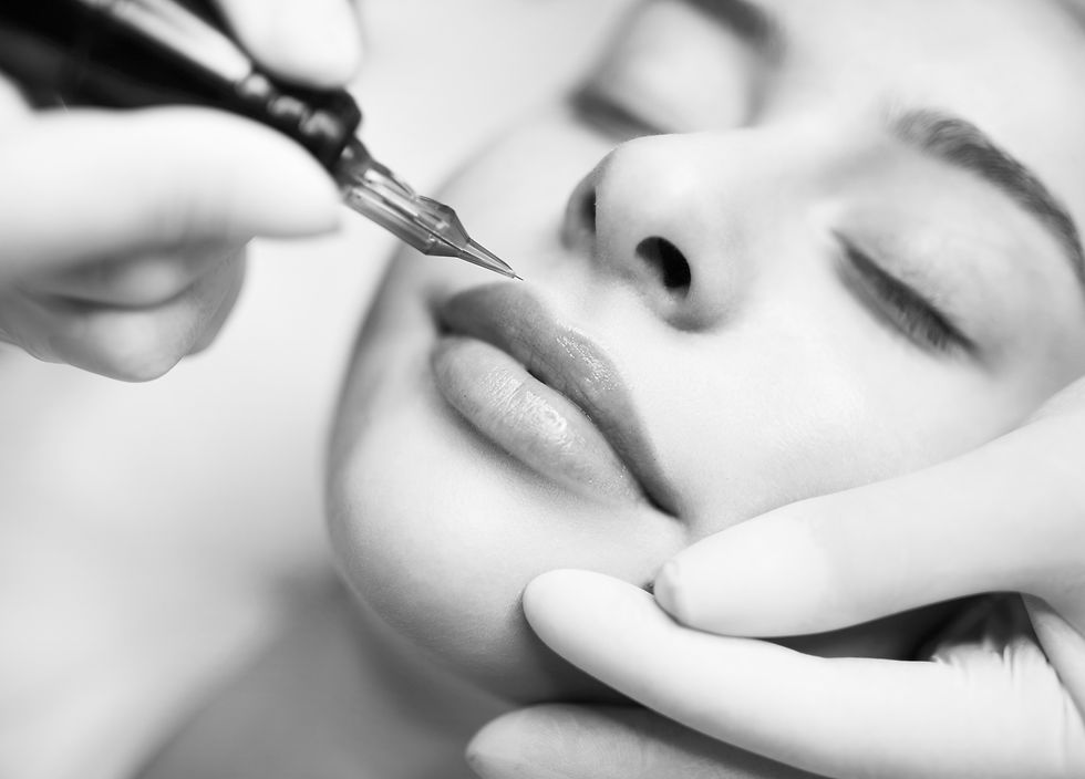 PMU Concept. Professional Permanent Makeup Artist Doing Lip Blushing Procedure To Young Wo