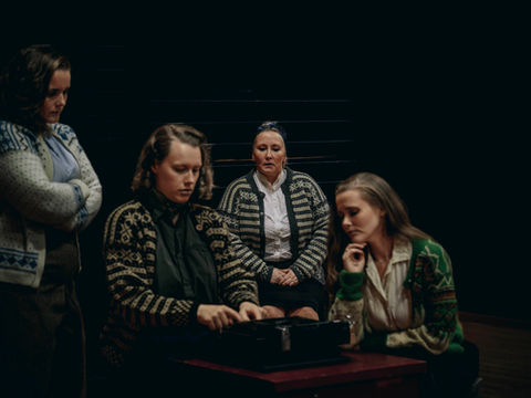 Fire damer som skriver på en skrivemaskin