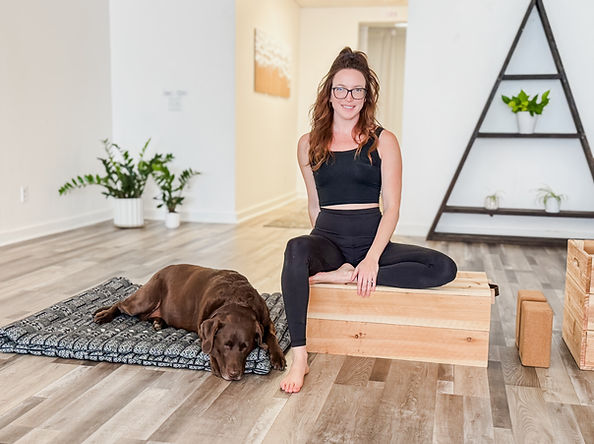 Justina Krusinga sitting in the Creative Core studio with Jade, her calm studio companion, symbolizing grounded presence and intuitive connection.