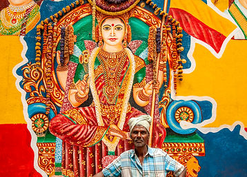 21 A man poses in front of a mural on one of the millions of hindu goddessess in Bangolore