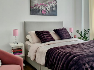 Styled guest bedroom with plum accents, soft furnishings and modern furniture in a Chislehurst home.