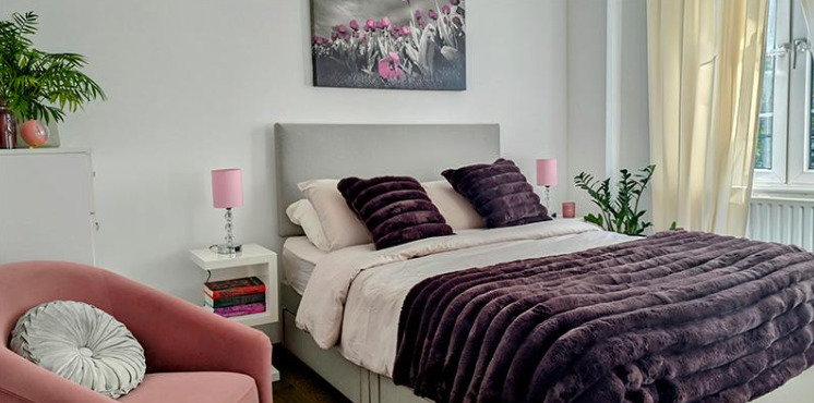 Styled guest bedroom with plum accents, soft furnishings and modern furniture in a Chislehurst home.