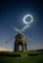 Stone windmill at night with a light halo in the sky