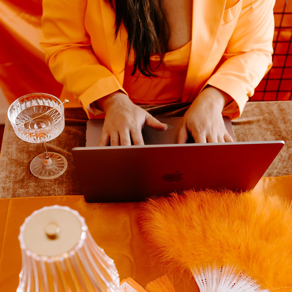 Girl on laptop, champagne glass, orange fan, lamp