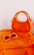 Orange purse and orange sunglasses on an orange table