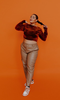 Co-founder of Mango Marketing Co. Natty posing in front of orange backdrop