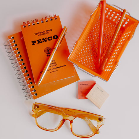 Orange things: Two orange notebooks, orange pen, two orange markets, two little to-do list post-its and orange plastic framed glasses