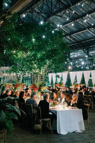 Elegant tablescape surrounded by lush greenery for corporate dinner at garden venue in Metro Detroit