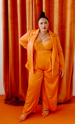 Co-founder of Mango Marketing Co. Alicia standing in front of orange fabric backdrop
