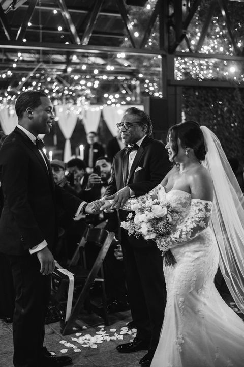 Father of bride giving blessing to couple during a romantic indoor garden wedding ceremony
