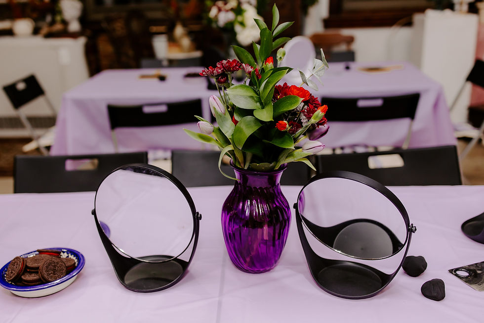 Purple table with flowers and purple vase, oreo cookies and two mirrors