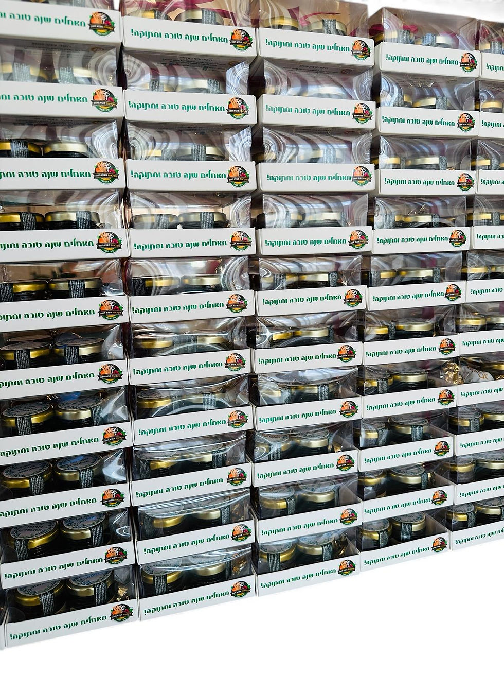 תמונה ממוזערת: מארזי מתנה לראש השנה מסודרים בשורות, עם צנצנות דבש וסילאן, ריבת תות ופרלינים