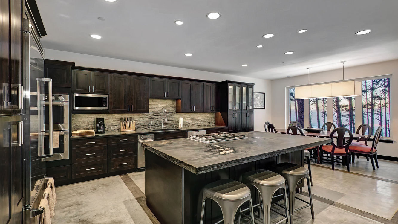 Large Eat In Kitchen with Dark Espresso Java Stained Wood Semi-Custom Cabinetry. Pantry Cabinets have been Customized to Include Glass Door Uppers to Complement the Adjacent Dining Area with Large Window.