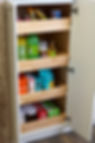 This image shows the bottom half of a tall pantry cabinet with roll-out trays installed. Once the pantry cabinet doors are open, these built-in trays (that function like drawers) can be easily pulled out to increase visibility and access to items in the back.