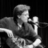 Xurxo Romani performing with a hurdy-gurdy at a live concert. A master of traditional folk music and innovative compositions, Romani showcases his skills on this unique instrument.