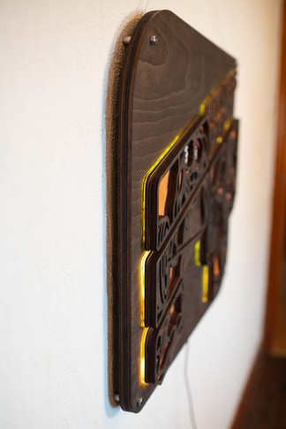 Wall-mounted dark panel with glowing yellow light design