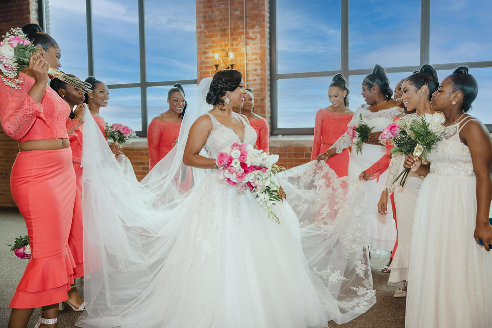 bridesmaids holding brides veil and smiling