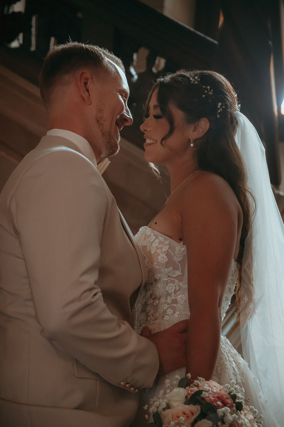 Intimer Editorial Wedding Moment. Ein Brautpaar steht sich gegenüber und lächelt sich an. 