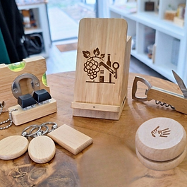 Auswahl an personalisierten Holzgeschenken inklusive Smartphone-Halter, Flaschenöffner mit Messer, Jojo und Wasserwaage mit individueller Gravur – Acousticsart Werndorf.
Smartphone-Ständer aus Echtholz mit detaillierter Lasergravur eines Wein-Motivs und integrierter Ladekabel-Führung.
Kompakte Wasserwaage aus Holz mit integriertem Flaschenöffner und Schlüsselring, individuell graviert – Acousticsart.
Klassisches Jojo aus Naturholz mit feiner Gravur einer helfenden Hand, ideal als personalisiertes Mitbringsel.