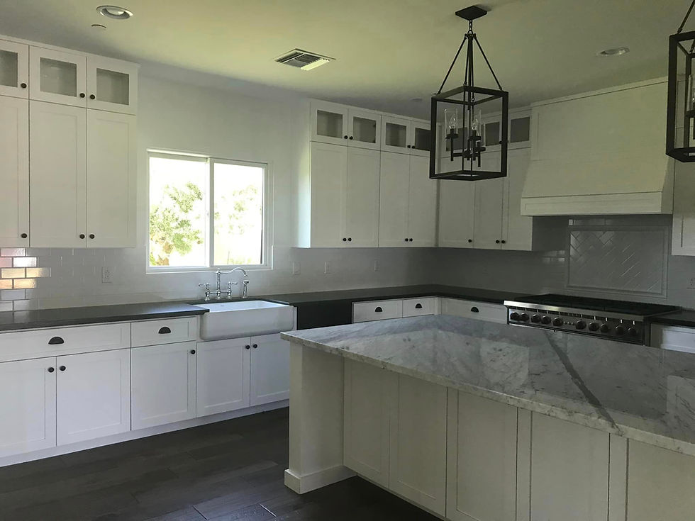 White shaker style Euro-American cabinets with black cabinet hardware and white granite counter tops