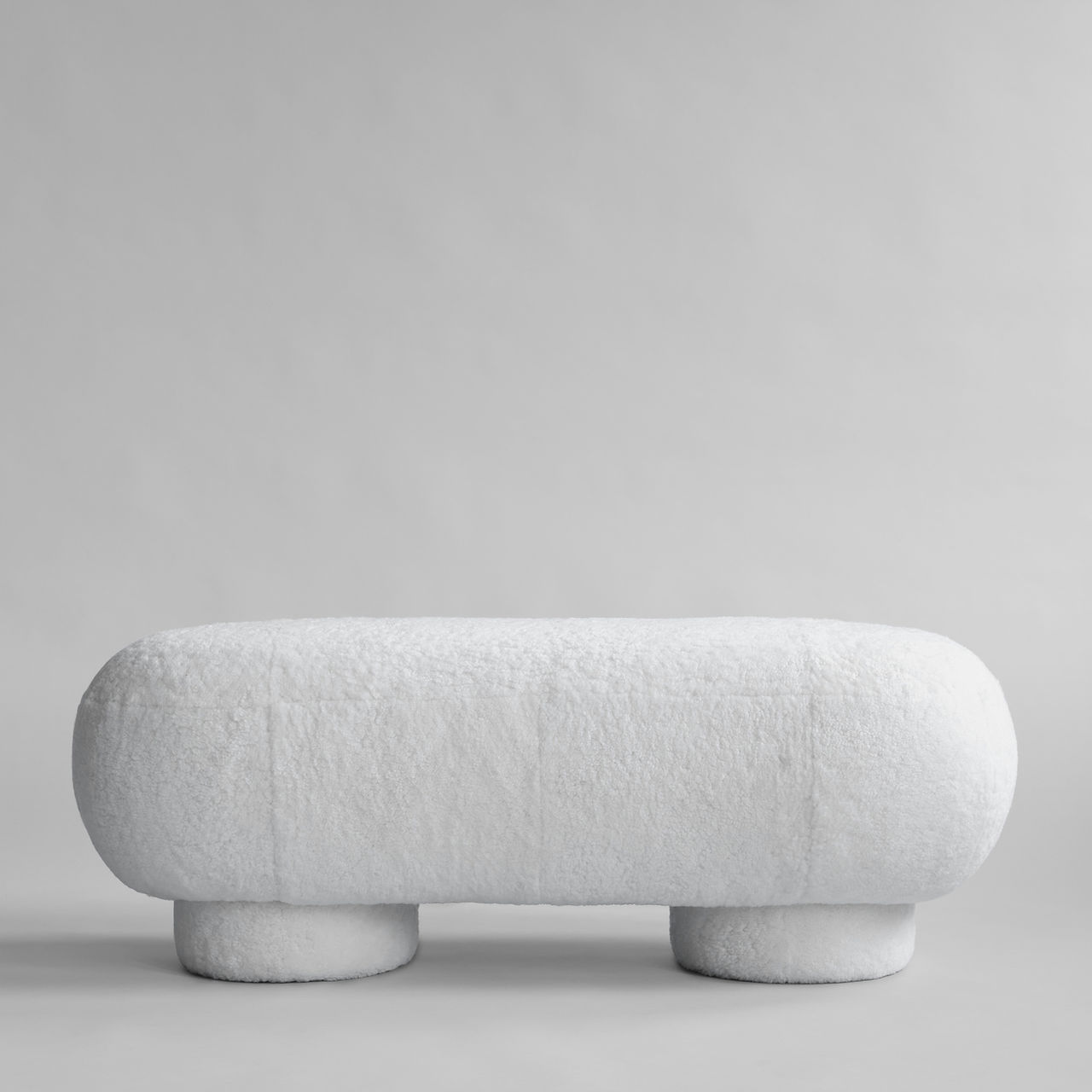 Big Foot Collection by 101 Copenhagen, coffee tables, side tables, benches and stools in fibre concrete and upholstered in sheepskin and linen, modern minimalist pieces for home, hotel, restaurant, office or lobby.