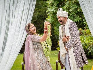 a hindi wedding couple laugh together during their marriage ceremony