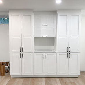 IKEA cabinets built around electrical panels and utility pipes.