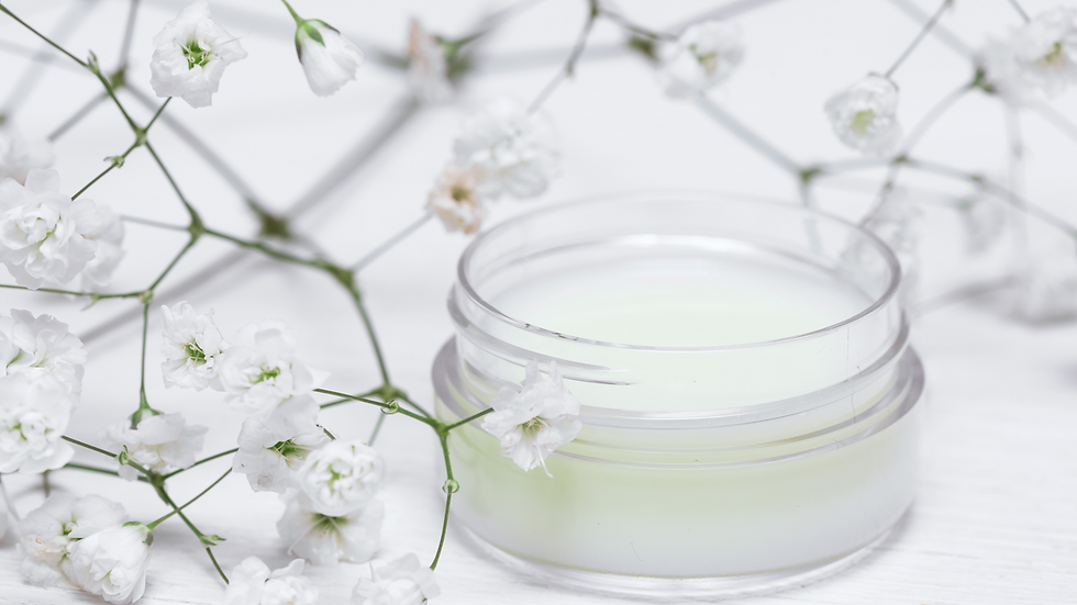 Schöne weiße Blumen in kombination mit einer Cremedose. Dies stellt die Frische und Reinheit unserer Produkte dar, die dazu beitragen, Ihre natürliche Schönheit zu betonen.