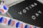 A roll of stickers that read "Voted" and a sign that adorned with Voting Day.
