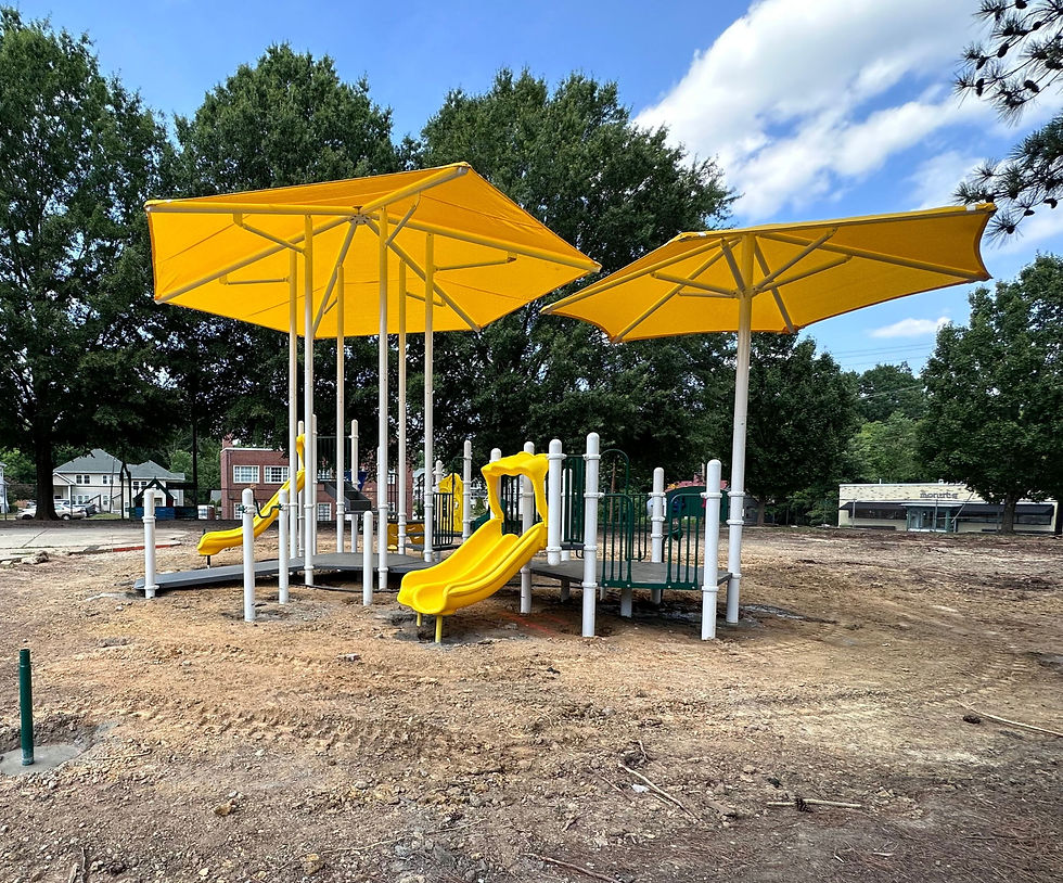 New playground with yellow slides and rectangular shade canopies.