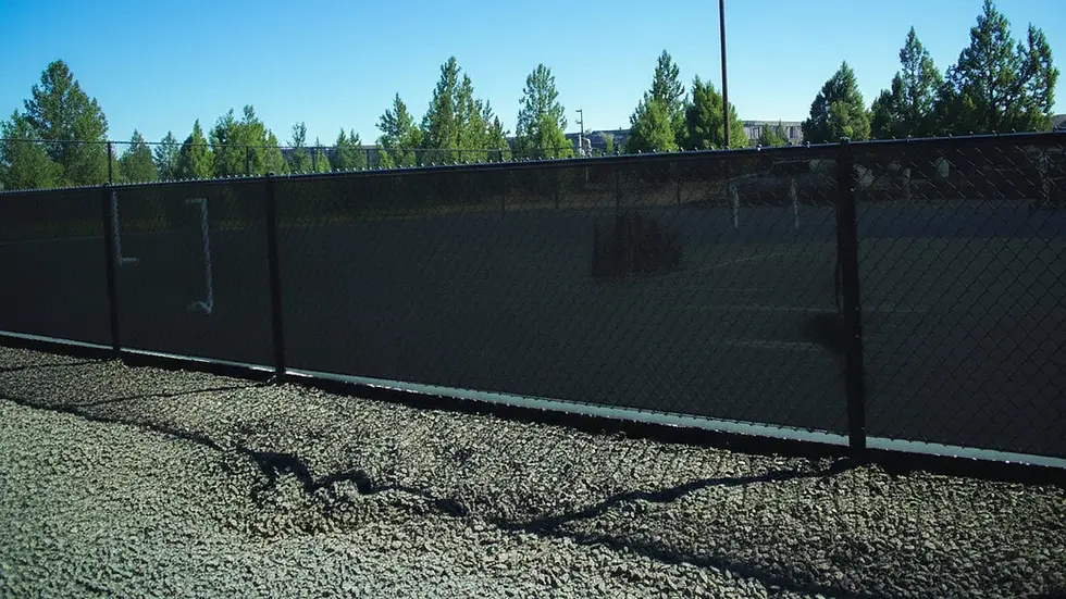 Black privacy windscreen attached to a chain-link fence