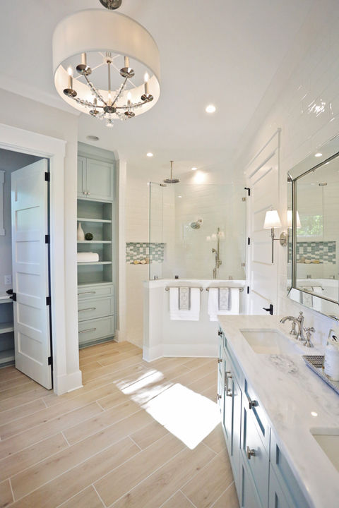 Bright, spacious bathroom with white cabinets and a large, open shower area.
