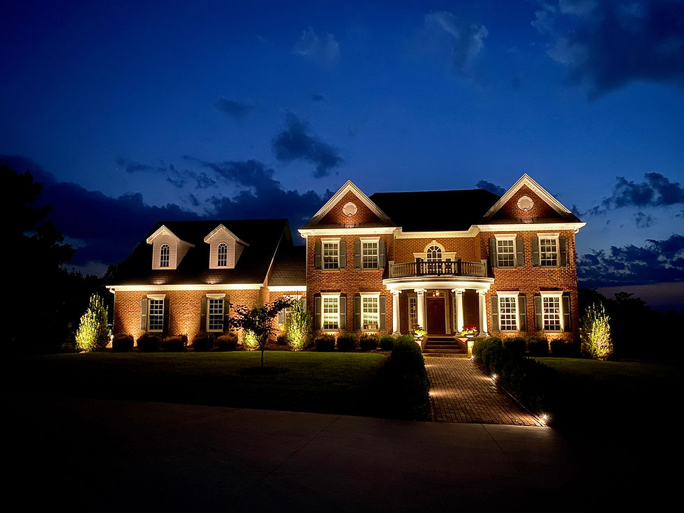 Brick house exterior illuminated by landscape lighting at night