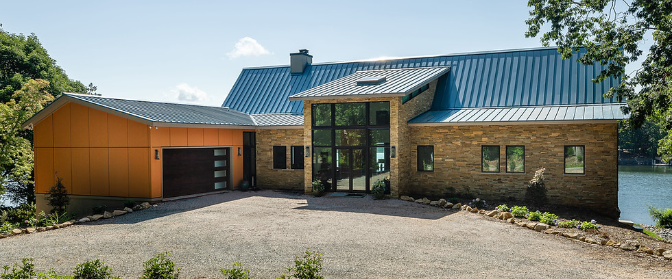 Modern home with blue metal roof and stone exterior.