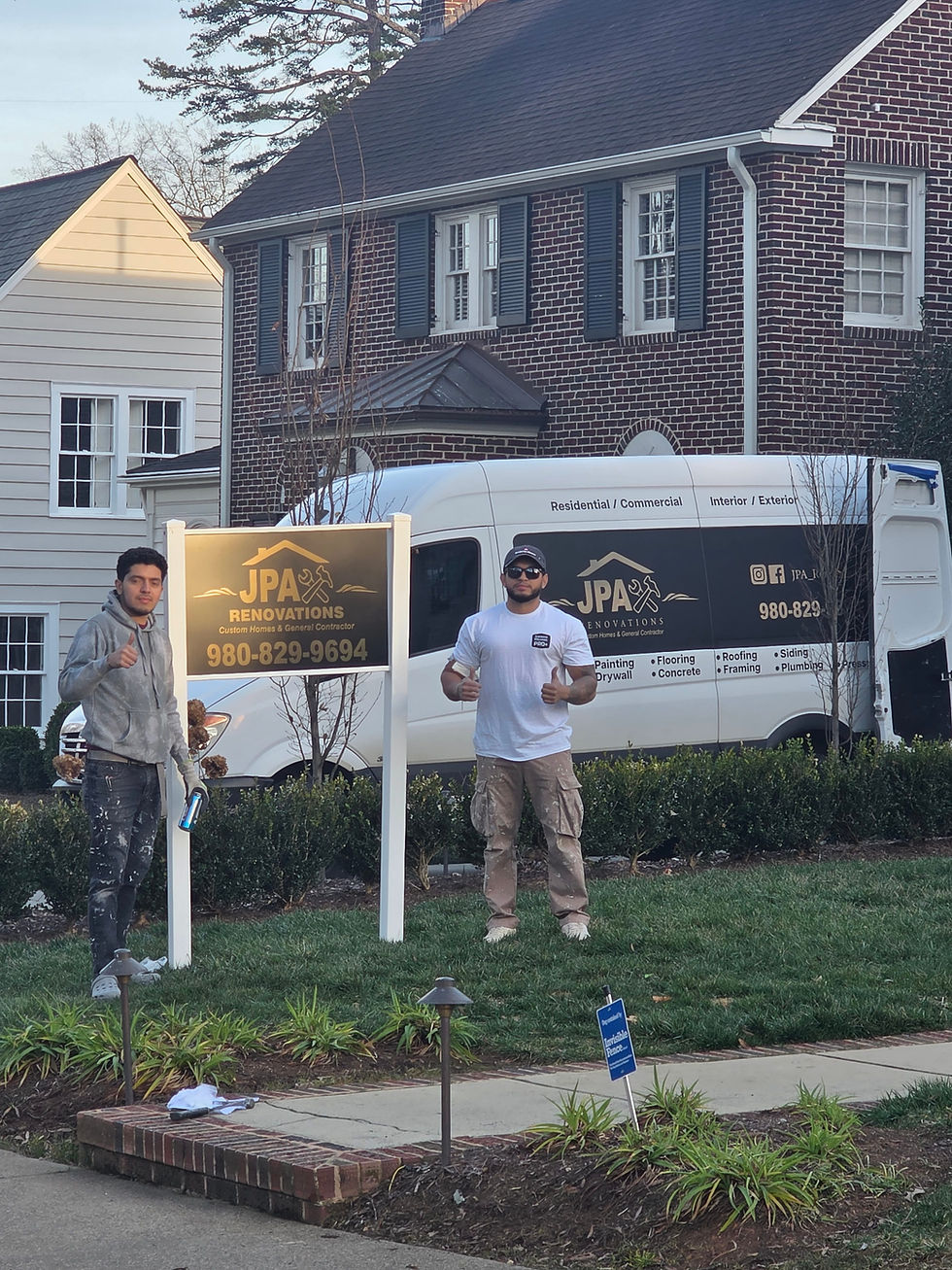 Two workers standing by a company van and yard sign.