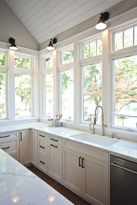 White kitchen with large windows, bright and airy, counter tops, sink