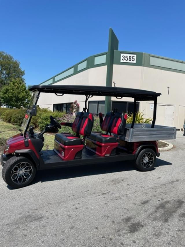 Red 6-seater utility golf cart with flatbed