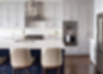 Modern kitchen with white cabinets and blue island with bar stools.