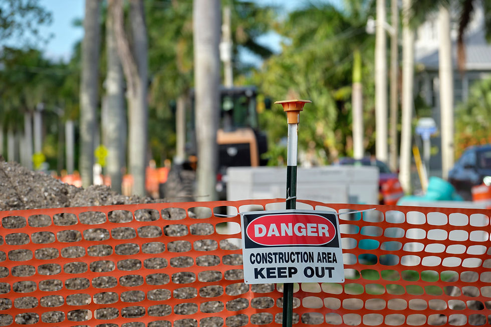 Orange safety fence with a Danger Construction Area sign.