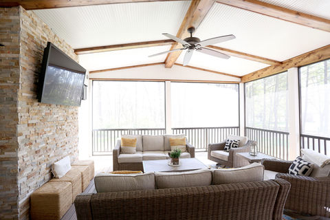 Cozy outdoor living room with television, sofa, and chairs. OUTDOOR LIVING. Turner Design Build.