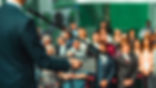 male-speaker-standing-in-front-of-microphones-2022-09-21-01-46-08-utc-min.jpg