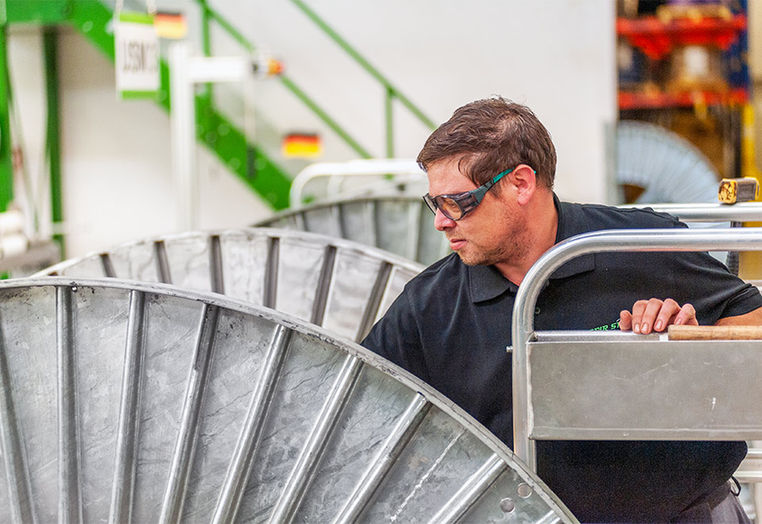Techniker inspiziert Metallteile in Fabrik