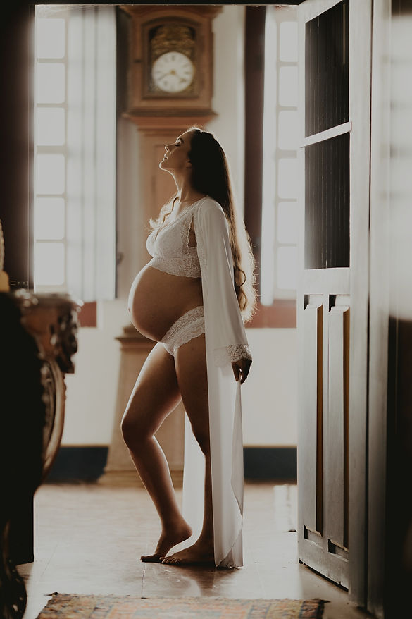 Pregnant woman in white robe, professional photography services.